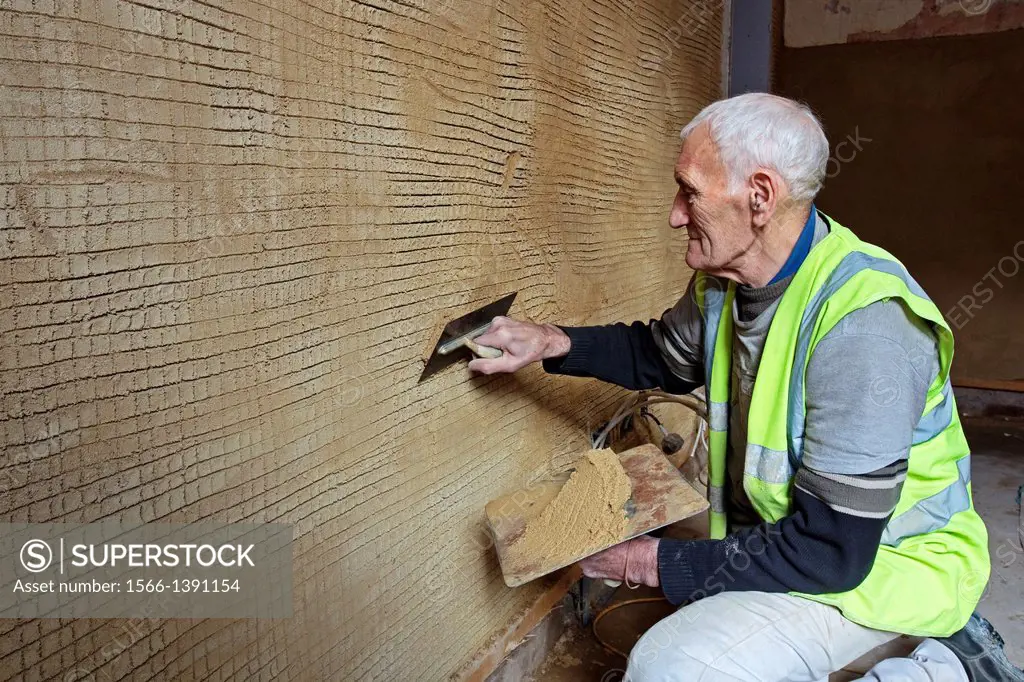 Traditional plasterer using traditional lime and mortar on a wall on the ground floor at Fairfield, Govan Road, Glasgow, Scotland, Great Britain, UK