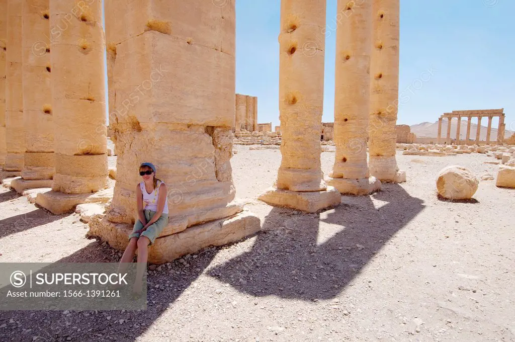 woman resting in the shadow of the columns Temple of Bel (Temple of Baal) in the ancient city of Palmyra, Syria 