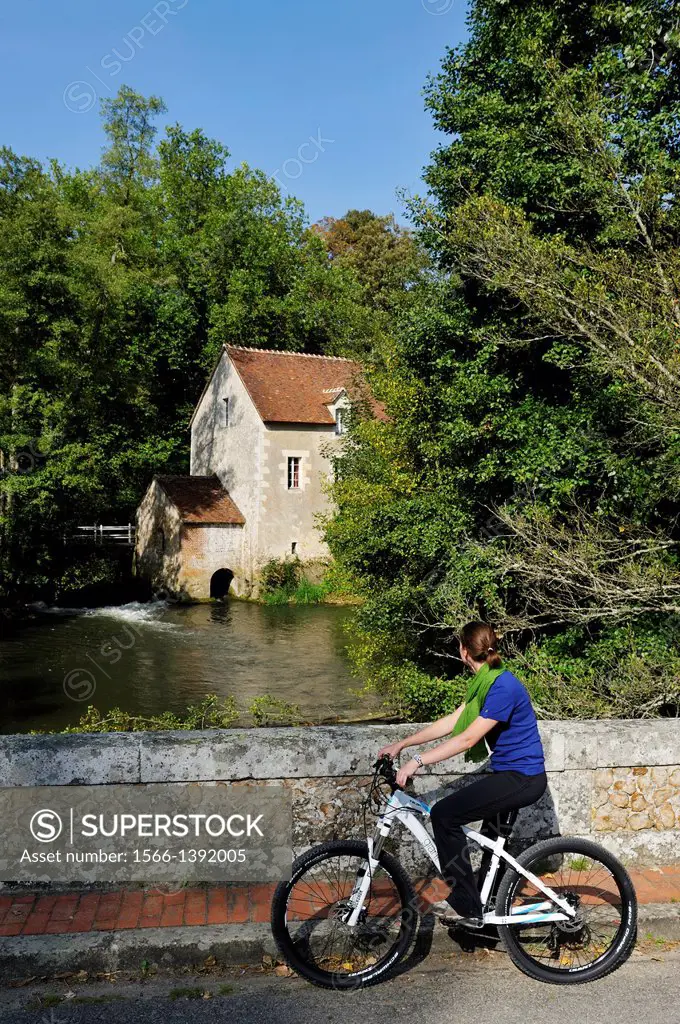 young woman on a bridge in front of a Water mill on the Huisne River bank at Dorceau, Orne department, Lower Normandy region, France, Western Europe.