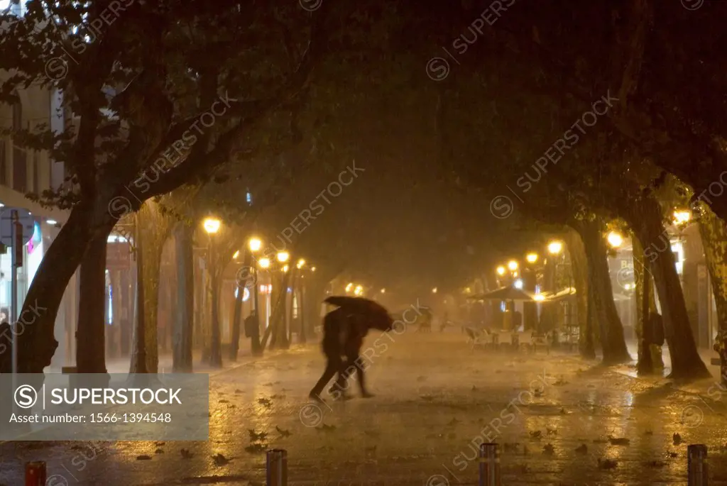 Couple with an umbrella under a heavy rain. Denia, Alicante, Comunidad Valenciana, Spain