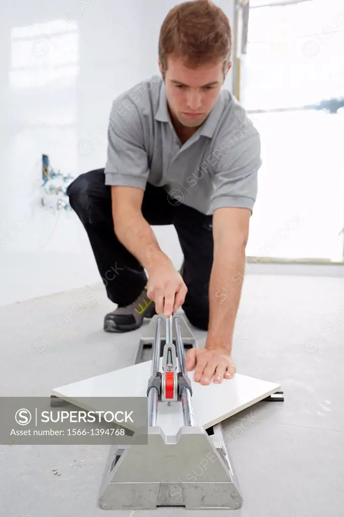 Bricklayer cutting tile. Manual tile cutter. Construction Industry.