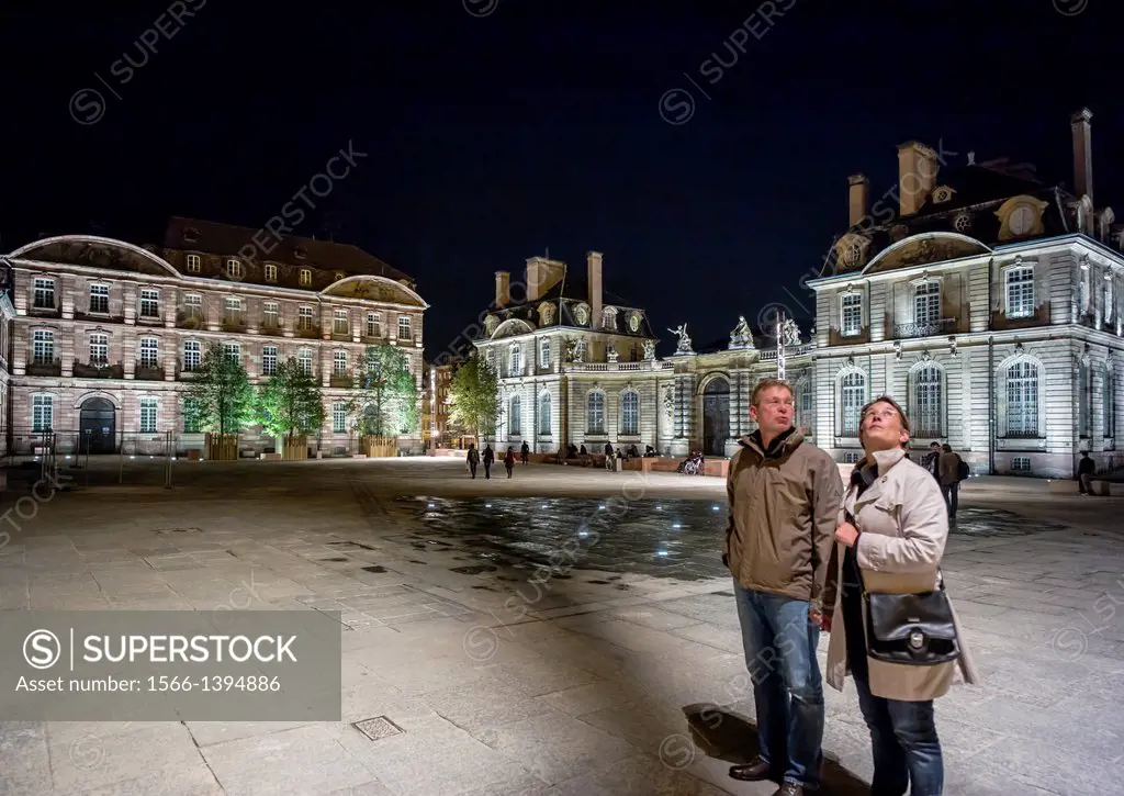 Couple in front of Lycée Fustel de Coulanges high school and Palais de Rohan palace at night Strasbourg Alsace France
