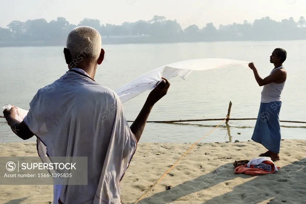 India, Bihar, Sonepur, Men drying a dhoti on the banks of the Ganges.