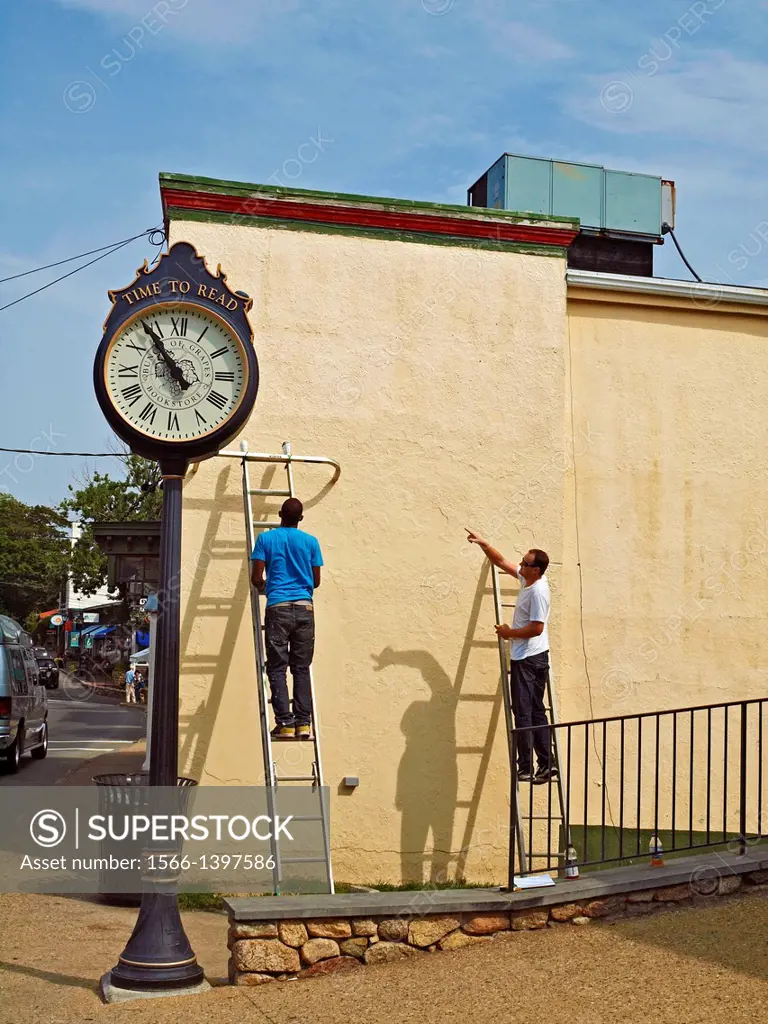 Workmen prepare to install a piece of art on an exterior wall in downtown Vineyard Haven, Martha's Vineyard, Massachussets.