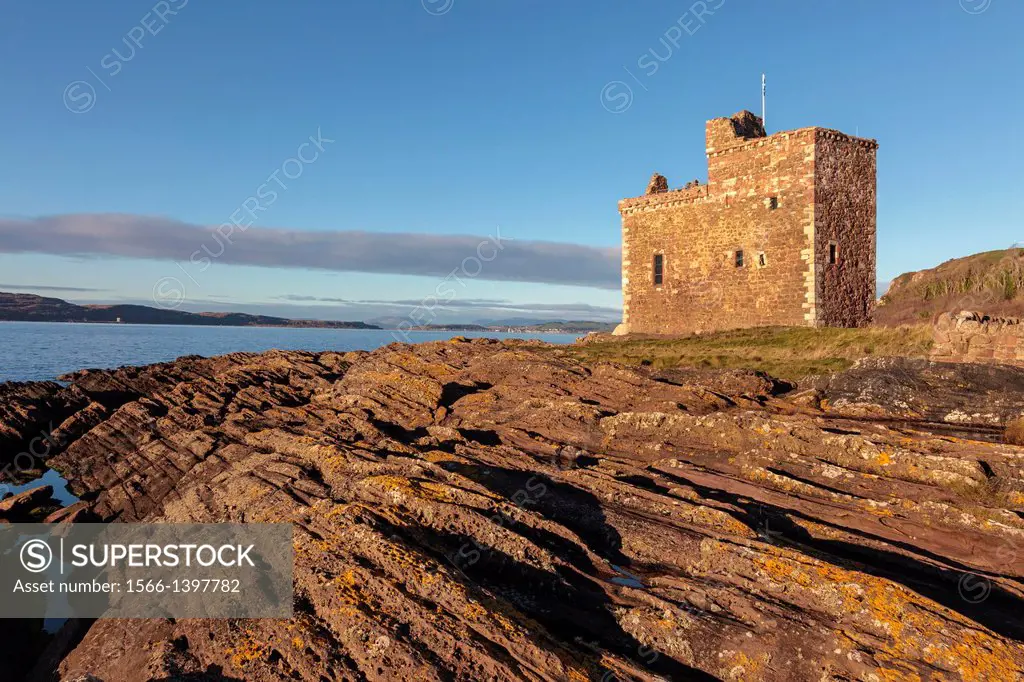 Portencross Castle, Ayrshire Scotland, UK, Great Britain, at sunset with a view north along the Firth of Clyde to the Isle of Millport o the horizon.
