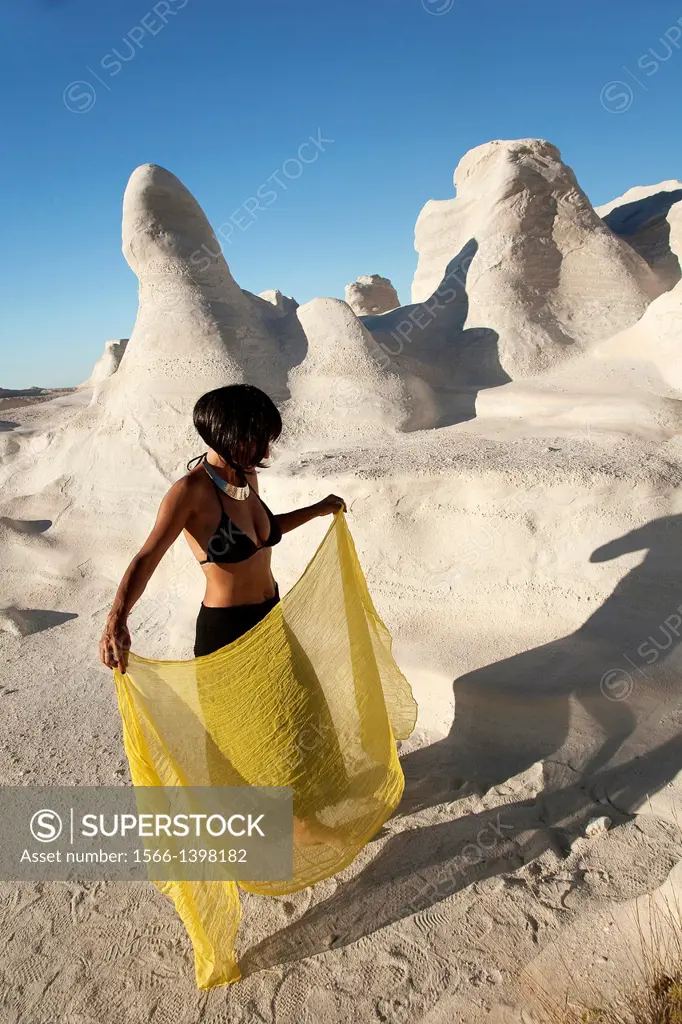 Woman posing near the white rock forms in Sarakiniko beach, Milos, Cyclades Islands, Greek Islands, Greece, Europe.