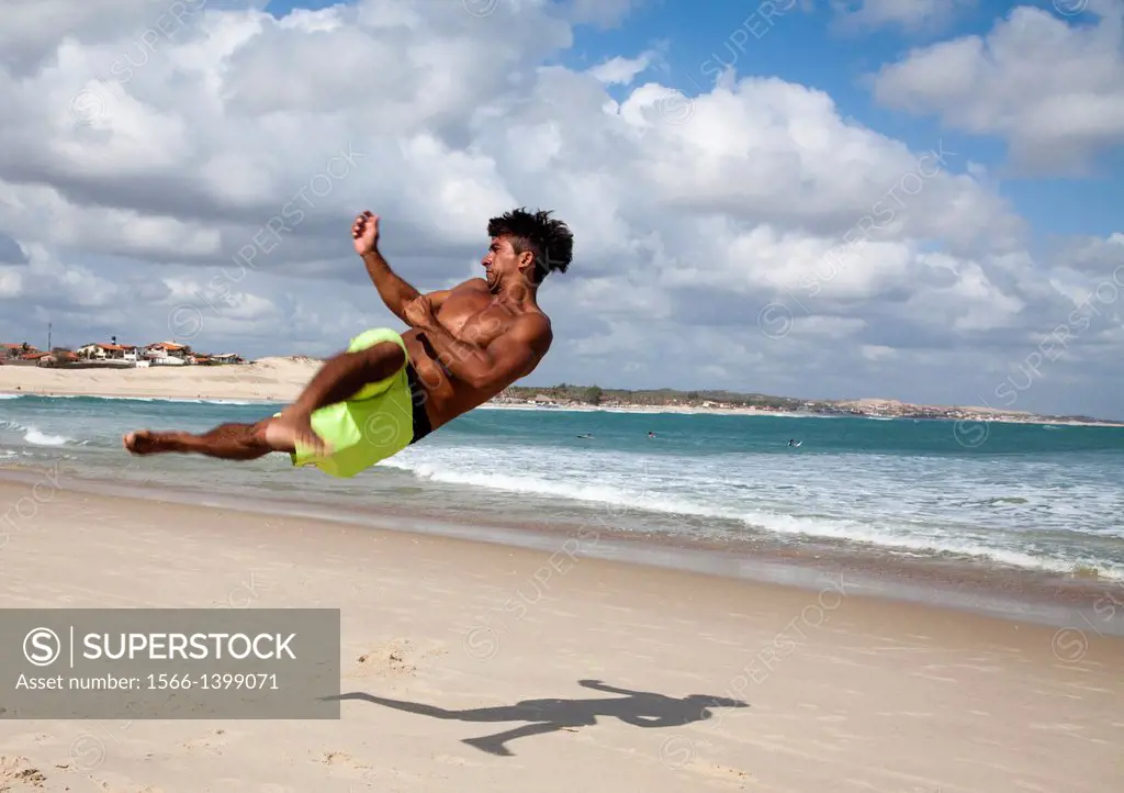 Man doing acrobatics on the beach in Iguape, Fortaleza district, Brazil.
