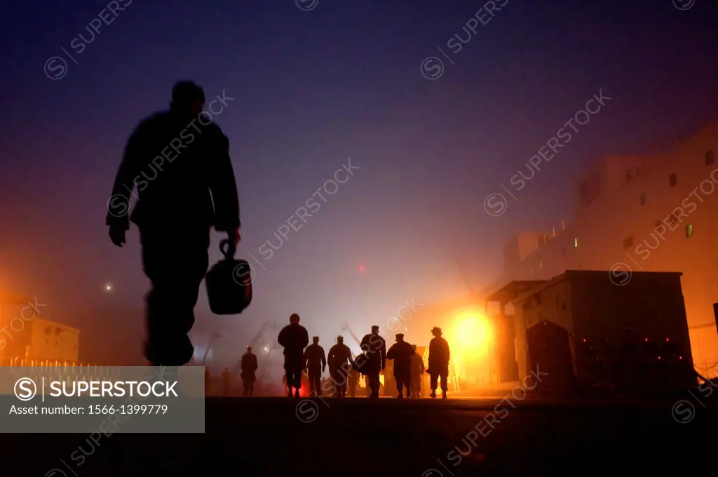 SAN DIEGO (Nov. 18, 2010) Sailors assigned to the amphibious assault ship USS Bonhomme Richard (LHD 6) walk through early morning fog to the ship and ...