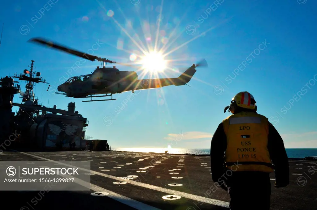 ATLANTIC OCEAN (Nov. 30, 2011) Aviation Boatswain's Mate 1st Class Jesse Seagrave watches as an AH-1W Super Cobra helicopter from the 2nd Marine Aircr...