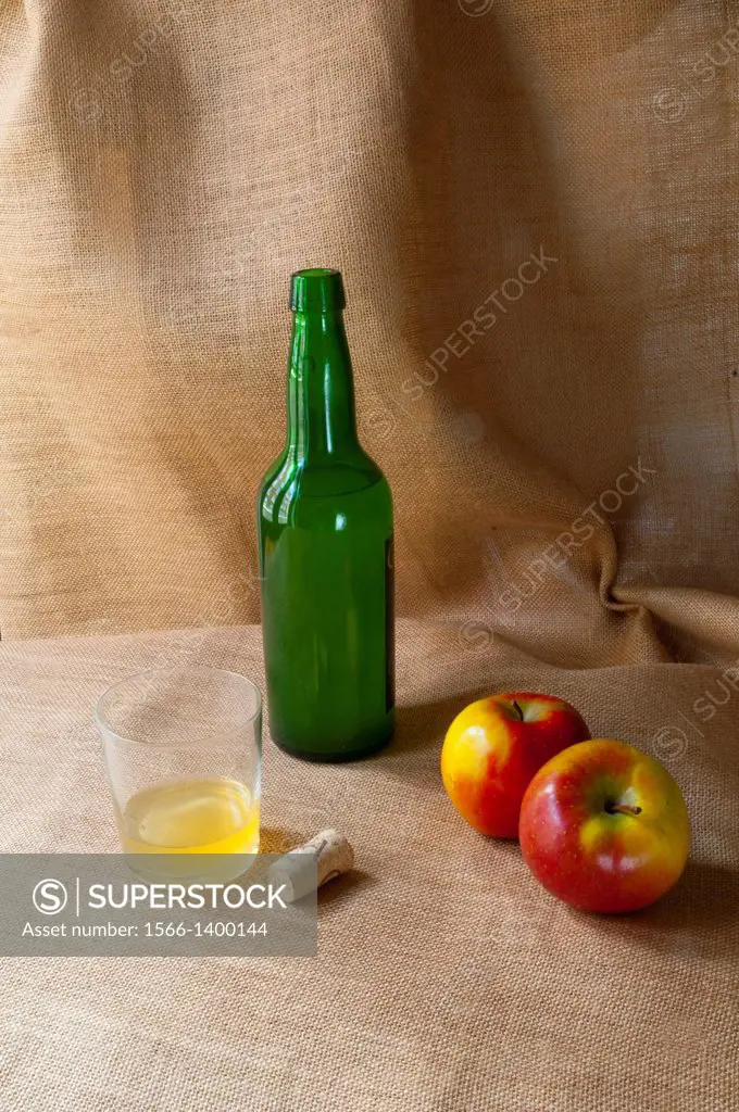 Asturian still life: bottle of cider, two apples, glass of cider and cork. Asturias, Spain.
