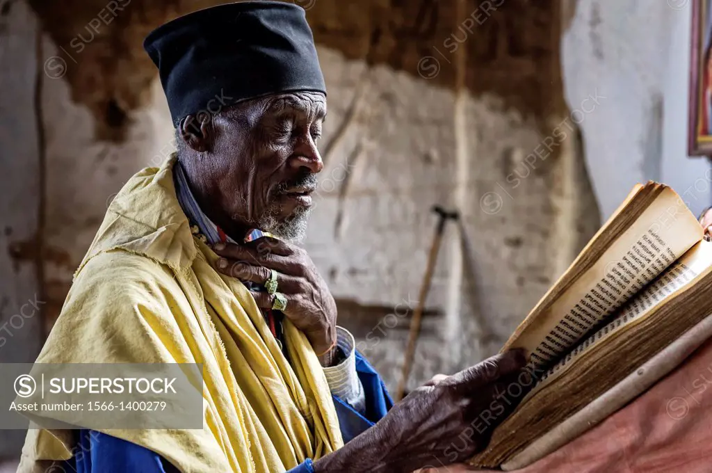 Old monk reading the Bible during the celebration of Orthodox Easter, Tigray, Ethiopia, Africa.