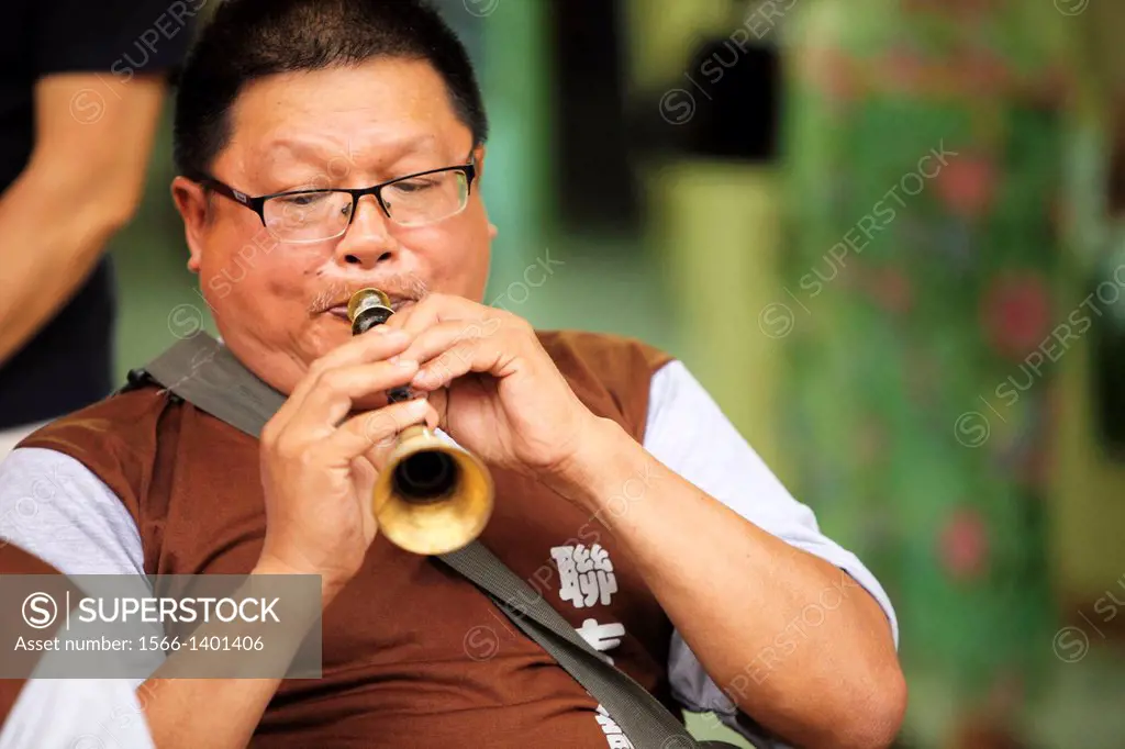 A man playing chinese musical instrument, borneo.