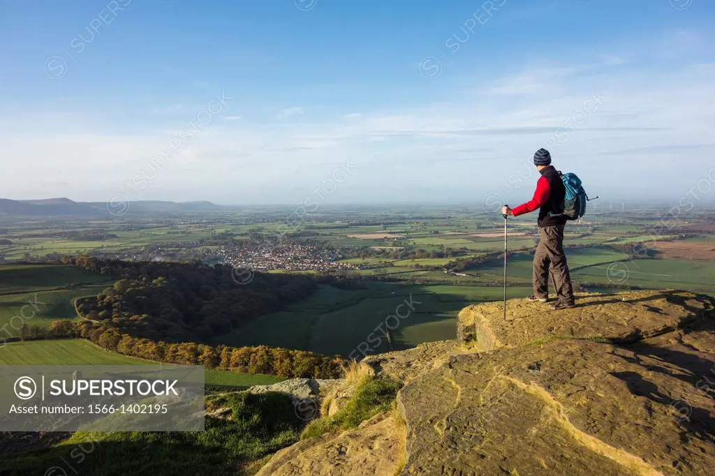 Walker on the summit of Roseberry Topping (nicknamed the `Yorkshire Matterhorn`) looking over Great Ayton village (boyhood home of Captain James Cook)...