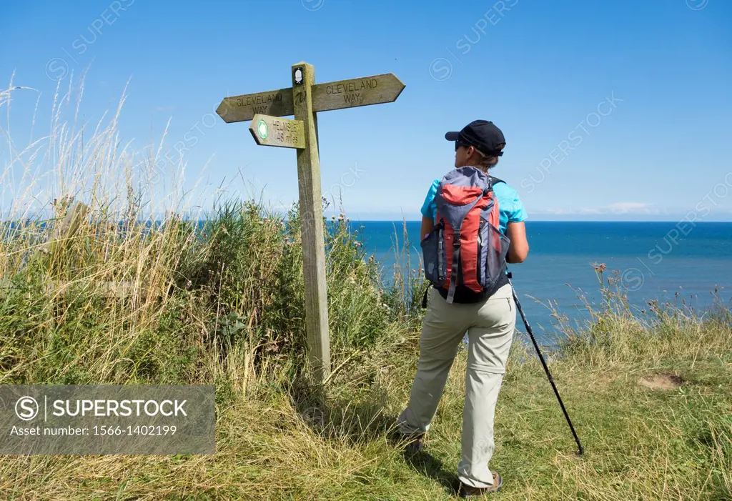 Female hiker on section of The Cleveland Way National Trail between Scarborough and Whitby on the North Yorkshire coast. England, United Kingdom.
