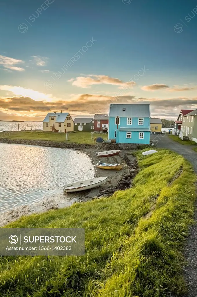 Homes and boats on the coastline of Flatey Island, Iceland.