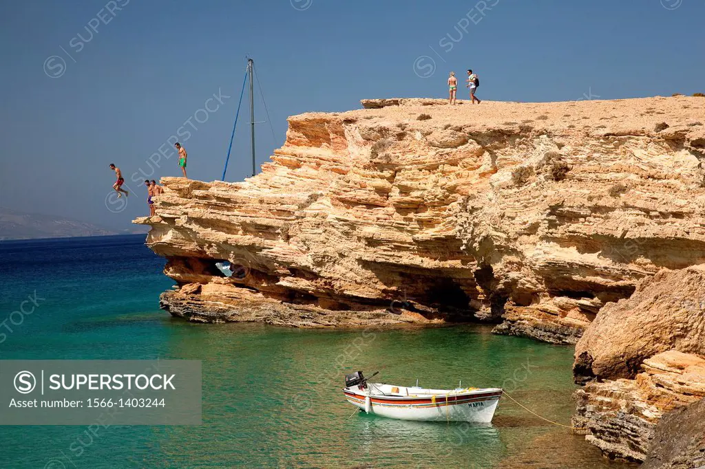 Men jumping from the rocks into the sea, Koufonissi, Cyclades Islands, Greek Islands, Greece, Europe.