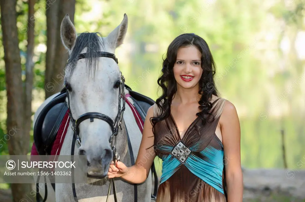 Close-up of a young woman standing beside a Quarab horse.