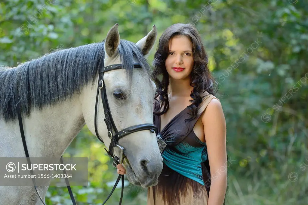 Close-up of a young woman standing beside a Quarab horse.