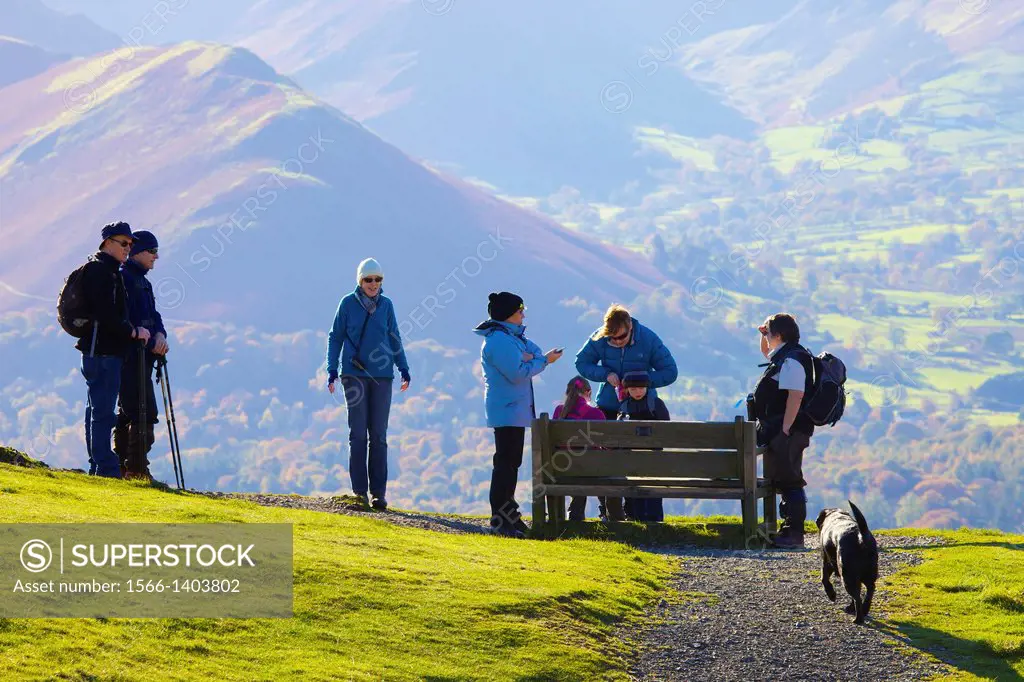 Tourists standing near and sitting on a bench, enjoying the view from Latrigg Lake District National Park Cumbria England United Kingdom Great Britain...