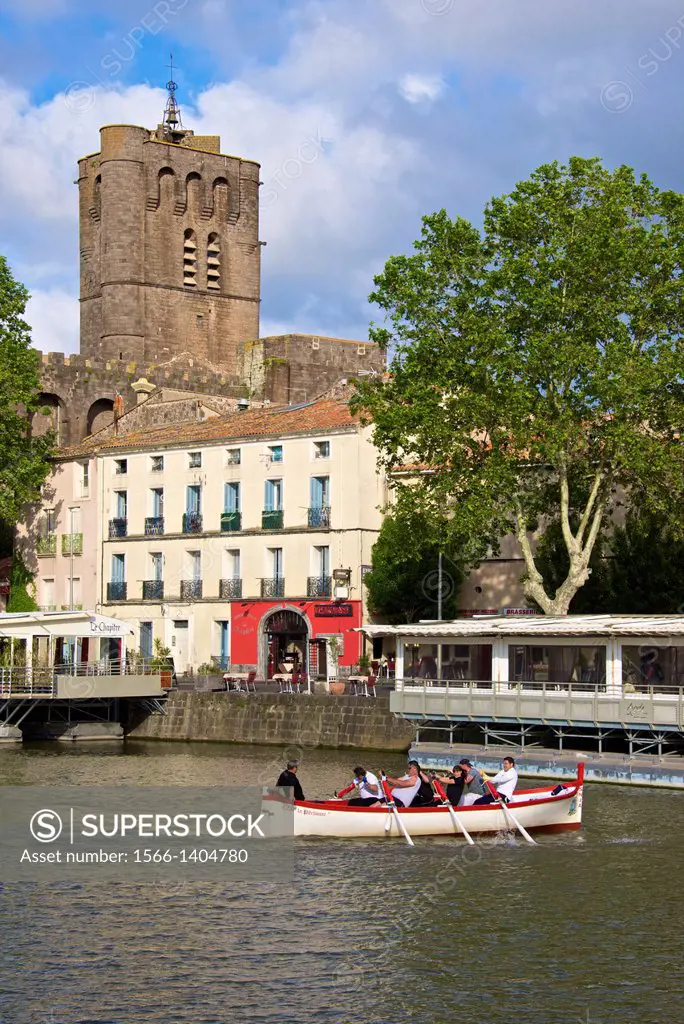 Fortified Ancienne cathédrale St Etienne, 12thc., built in black lava,and river banks with restaurants along Herault river, and jousters training, AGD...