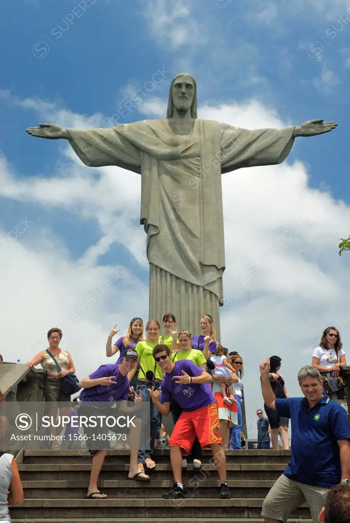 Brazil, Rio de Janeiro: Group of tourists posing for a photograph in front of the iconic Cristo Redentor statue on Corcovado. --- Info: Christ the Red...