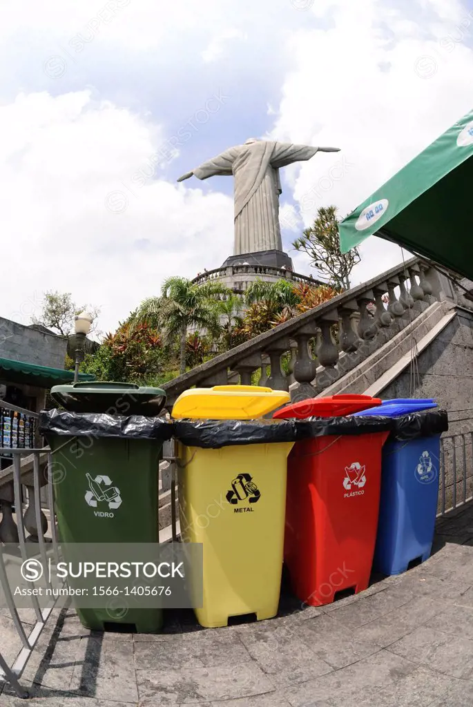 Rio de Janeiro, Brazil, Cristo Redentor statue on Corcovado. Four coloured waste bins lined up: green for glass (vidro), yellow for metal, red for pla...