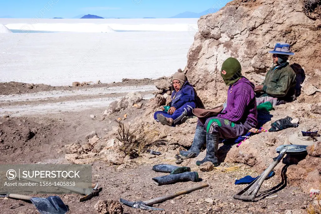 Three male miners resting on the rocks where they slept the night before on the edge of the salt flats where they extract salt, Salar de Uyuni, Bolivi...