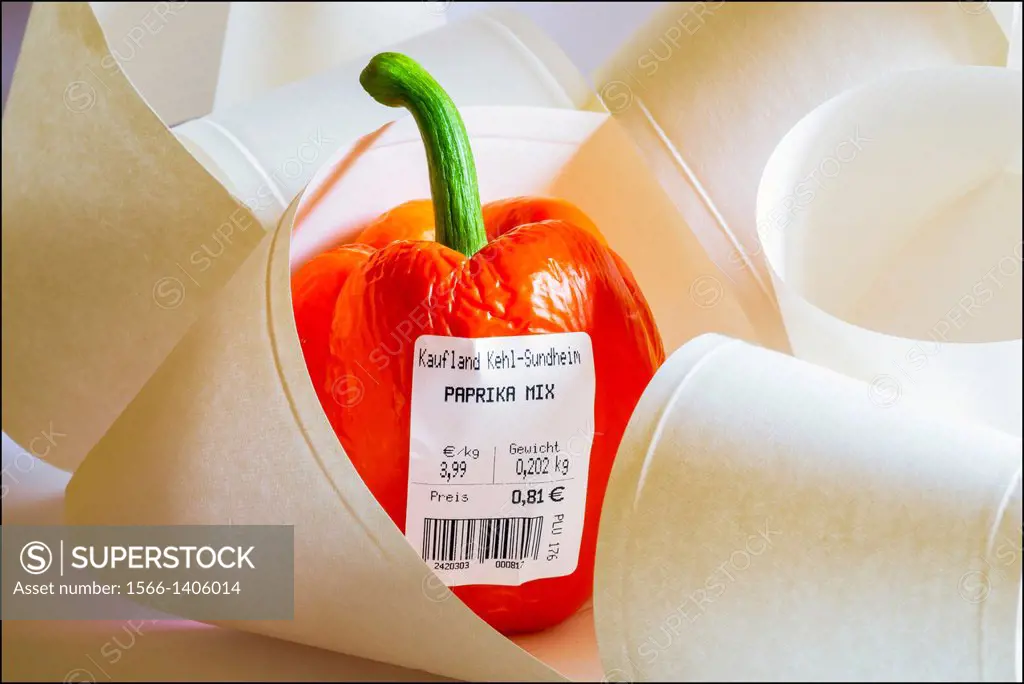 One red bell pepper with German bar-coded label showing weight and price in Euro among paper rolls.