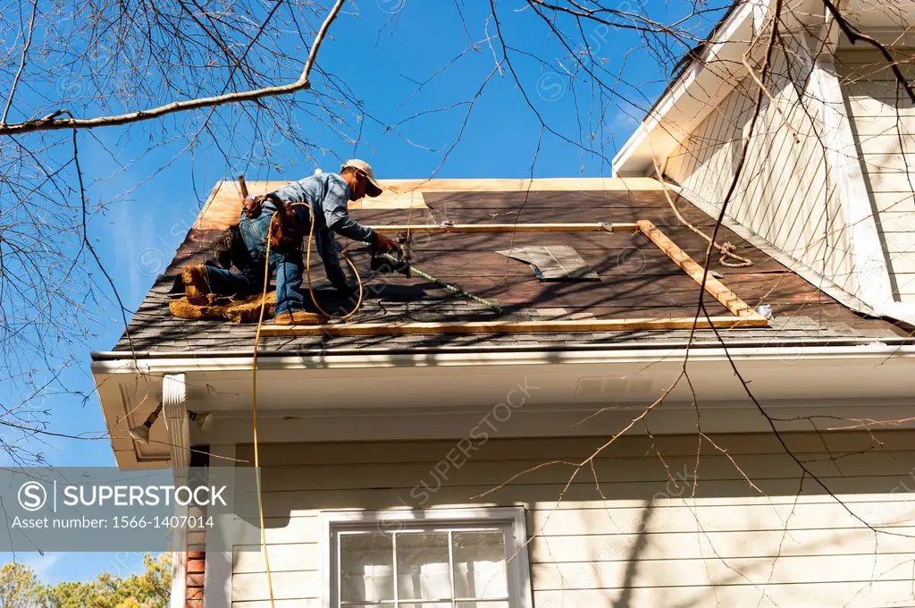A roofing crew installs new shingles on a house.