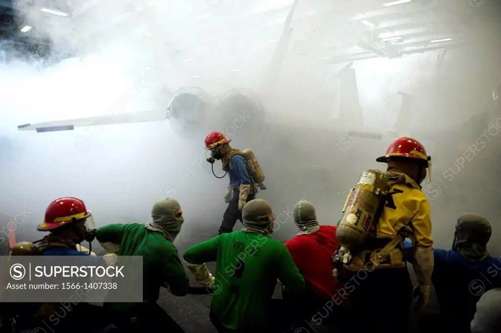 GULF OF OMAN (Dec. 13, 2013) Sailors fight a simulated fire during a general quarters drill in the hangar bay of the aircraft carrier USS Harry S. Tru...