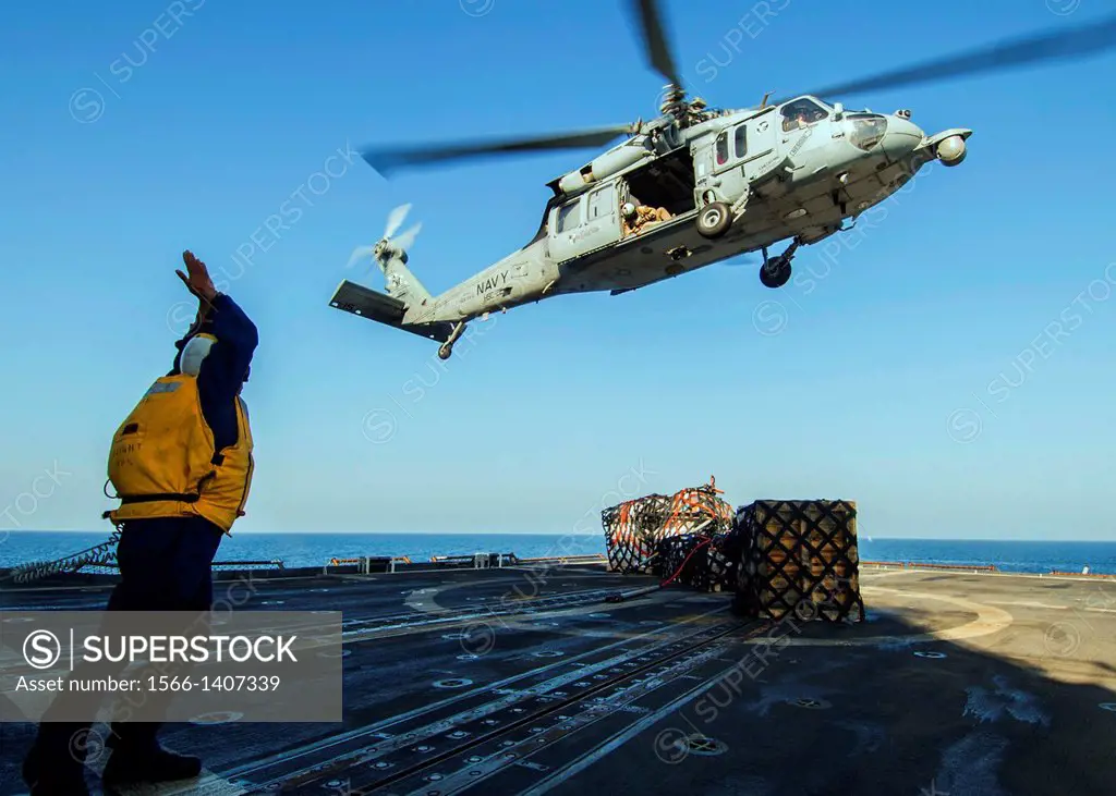ARABIAN GULF (Dec. 14, 2013) - Boatswain´s Mate 2nd Class Shane Hempfield signals to the pilot of an MH-60S Sea Hawk helicopter to launch after loweri...