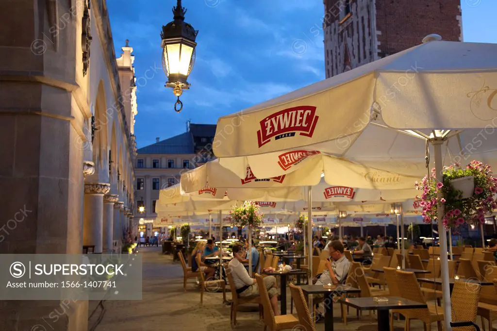 Cloth Hall and Town Hall Tower with Restaurant Cafe Terrace, Krakow; Poland, Illuminated at Night.