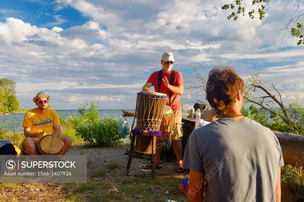 Drummers playing at Hanlan´s Point beach Toronto at sunset.