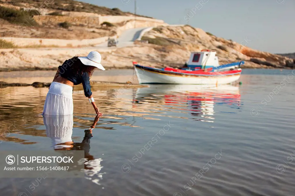 Woman playing with the water in the sea, Koufonissi, Cyclades Islands, Greek Islands, Greece, Europe.