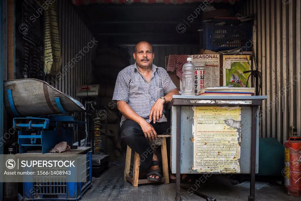 A man behind his desk at a government-run food distribution shop, operated from the back of a truck.