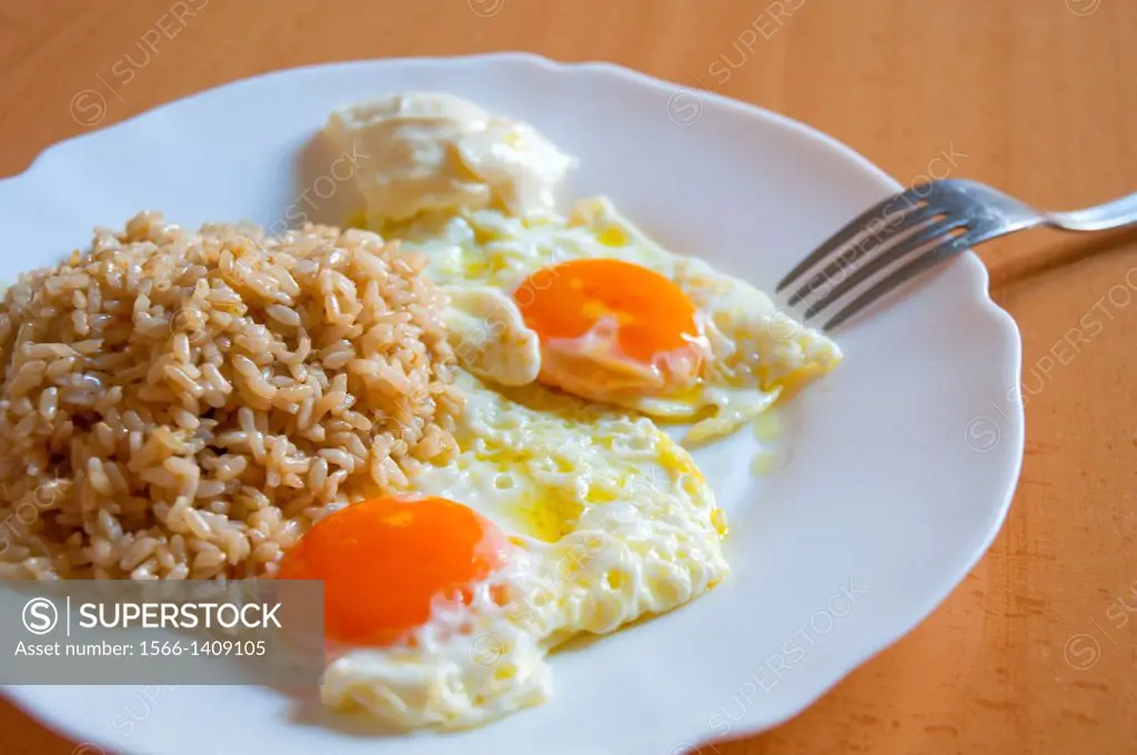 Two fried eggs with rice and alioli sauce. Close view.
