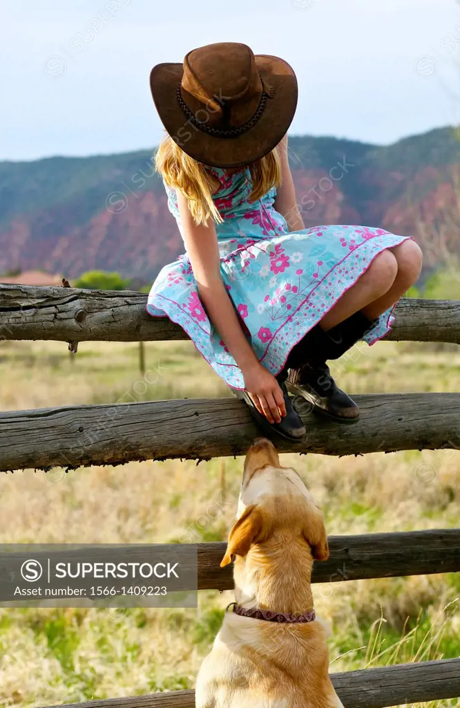 A young girl and her dog in the countryside in California, USA.