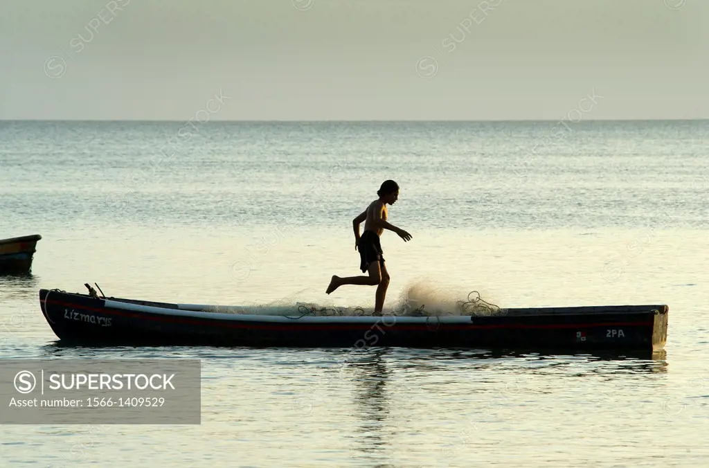 Fisherman preparing fishing net on a small boat near Farallon village, Cocle Province, Panama.