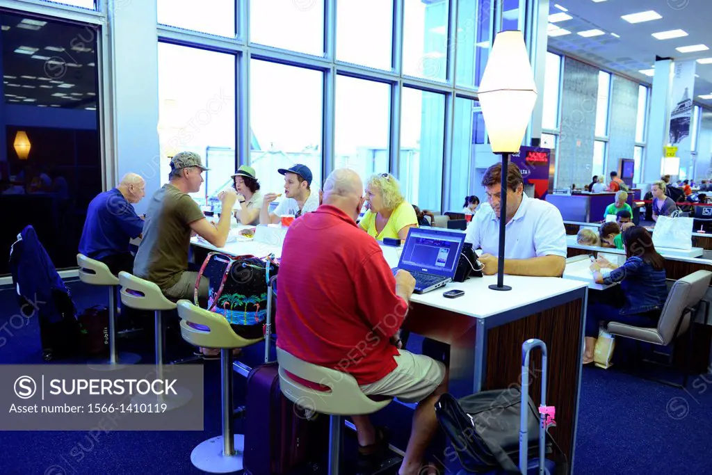 Travelers communicate with technology at airport JFK.