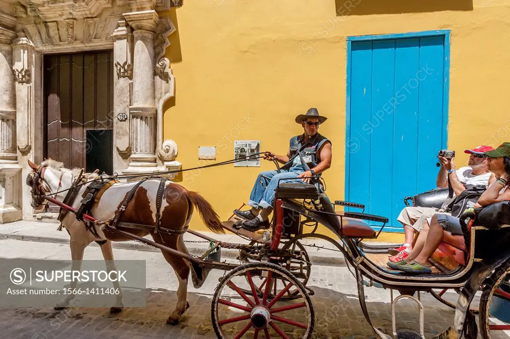 Tourists Taking A Traditional Horse and Carriage Ride, Havana, Cuba.