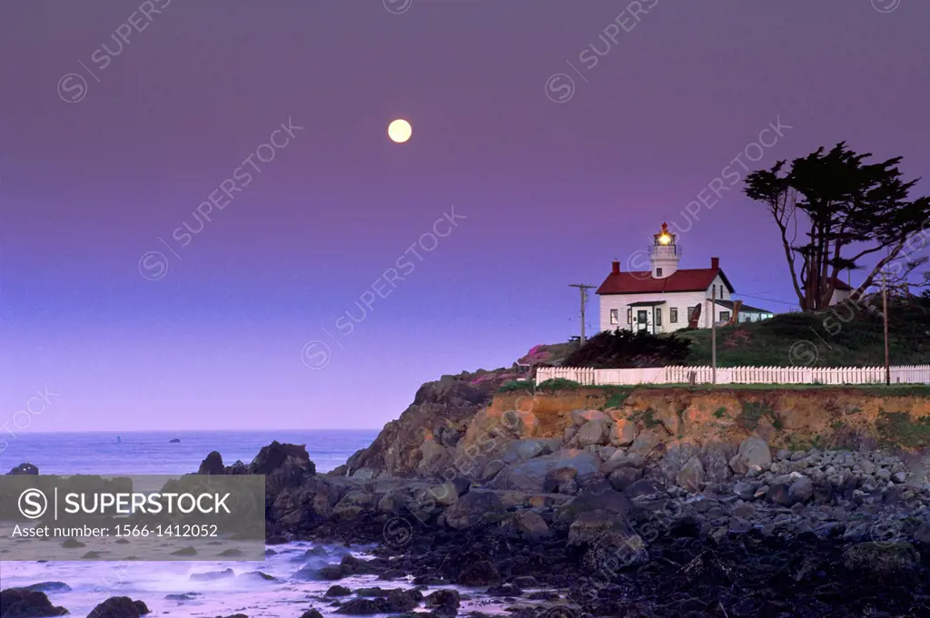 Full moon setting at dawn over Battery Point Lighthouse, Crescent City, Del Norte County, California.