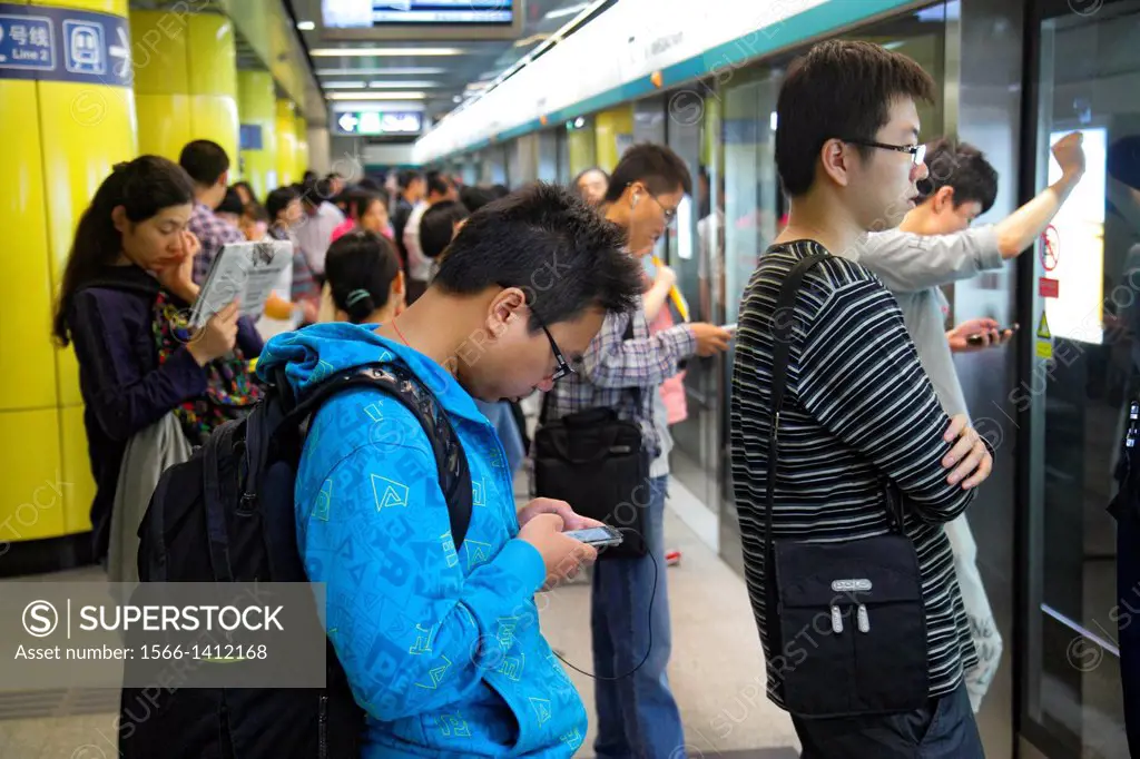 China, Beijing, Dongzhimen Subway Station, public transportation, passenger, rider, Asian, man, Line 2, platform, waiting, smartphone, texting,.