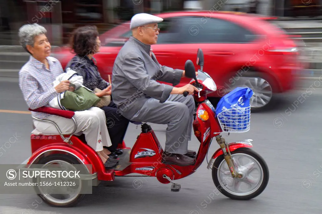 China, Beijing, Dongcheng District, street, traffic, Asian, man, woman, senior, electric tricycle moped, pedicab, cycle rickshaw, passengers,.