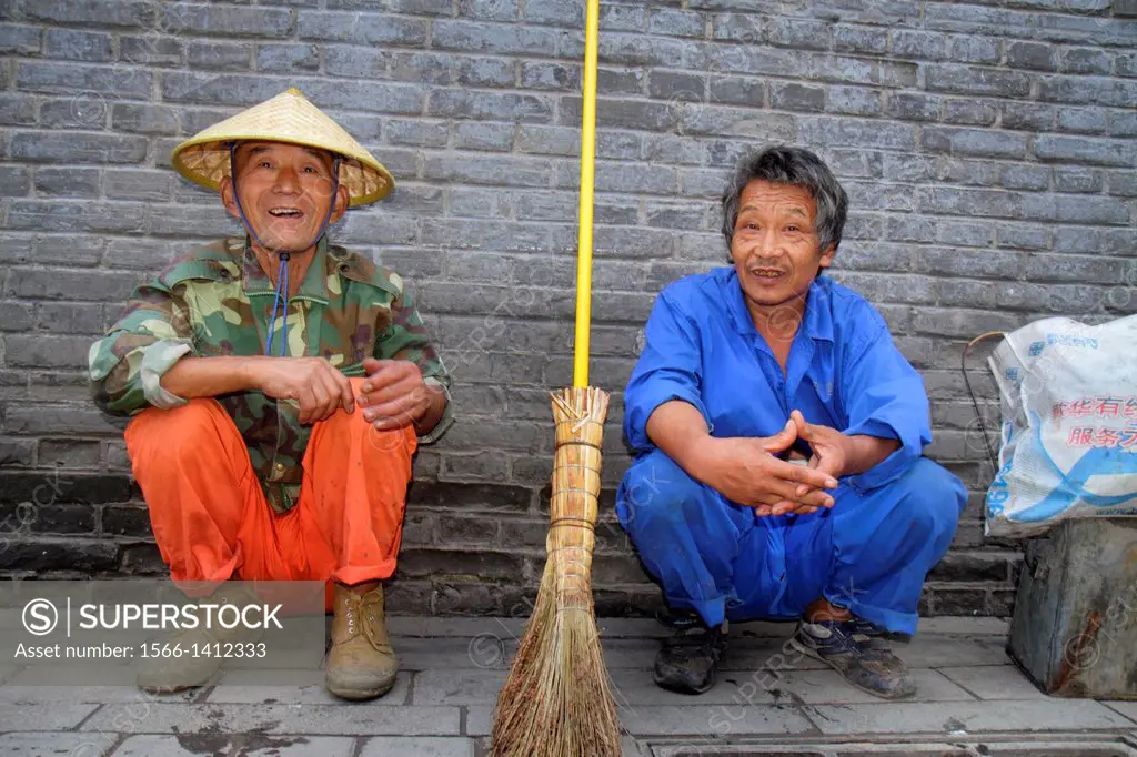 China, Beijing, Dongcheng District, Nanluoguxiang, hutong, historic, shopping, Asian, man, street sweeper, resting, squatting, sitting,.