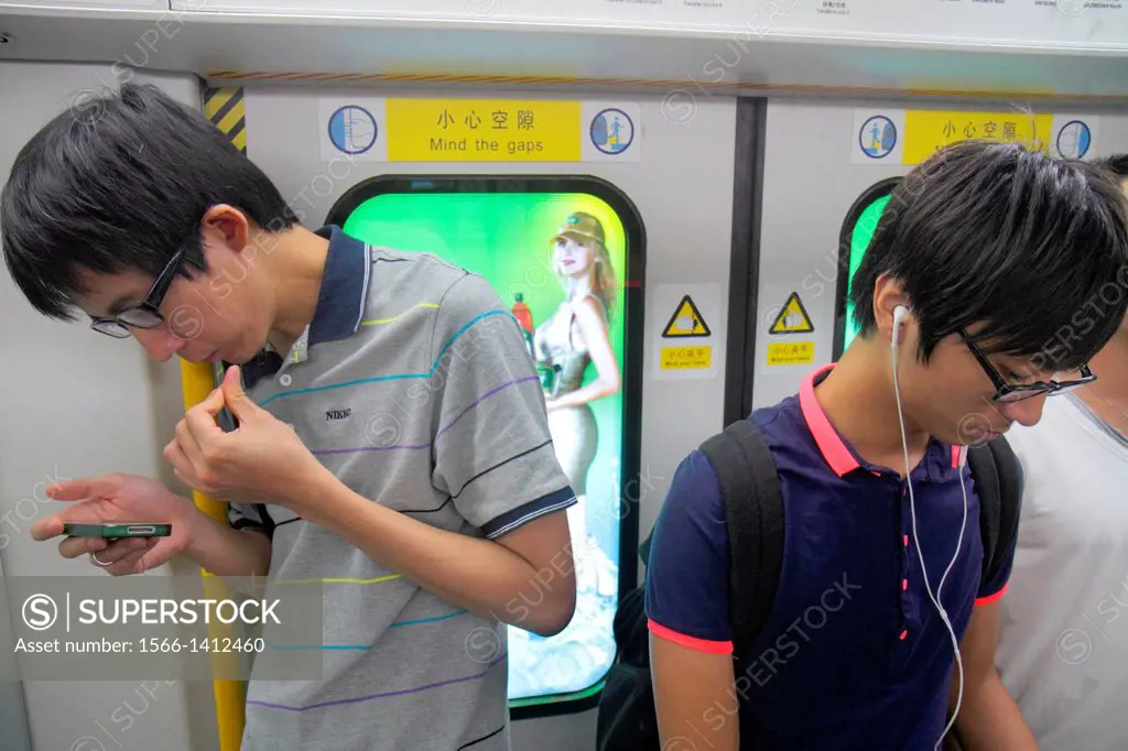China, Beijing, Dongzhimen Subway Station, Line 2 13, public transportation, passengers, riders, train cabin, Asian, man, standing, smartphone, lookin...