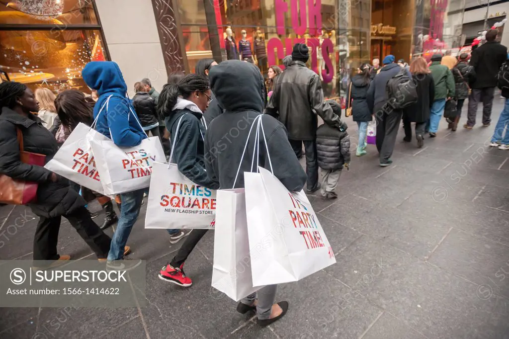 Shoppers with H&M shopping bags on Fifth Avenue in New York looking for bargains on Black Friday, the day after Thanksgiving. Many retailers, includin...