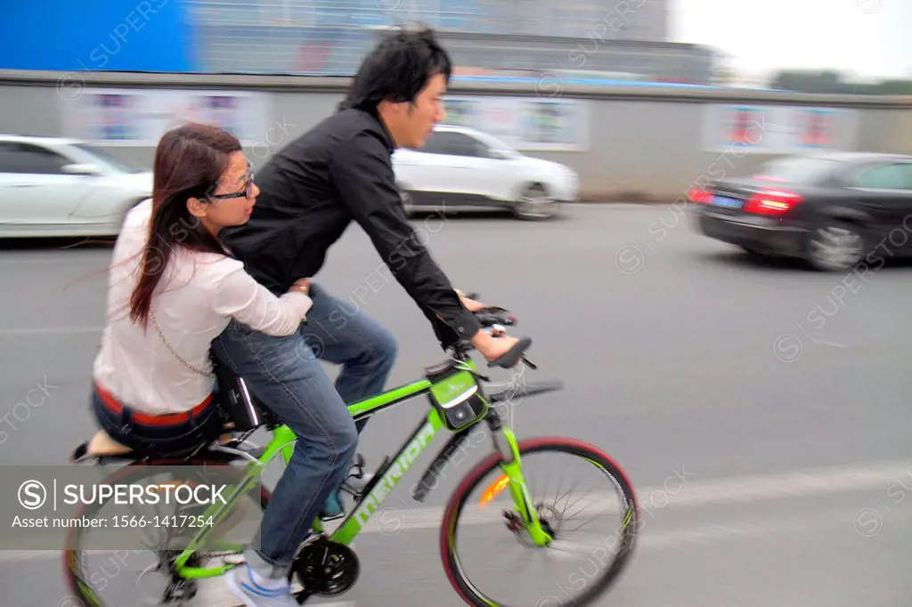 China, Beijing, Guang An Men Nei Da Jie, Guanganmen Inner Street, traffic, riding, bicycle, Asian, man, woman, no helmet,.