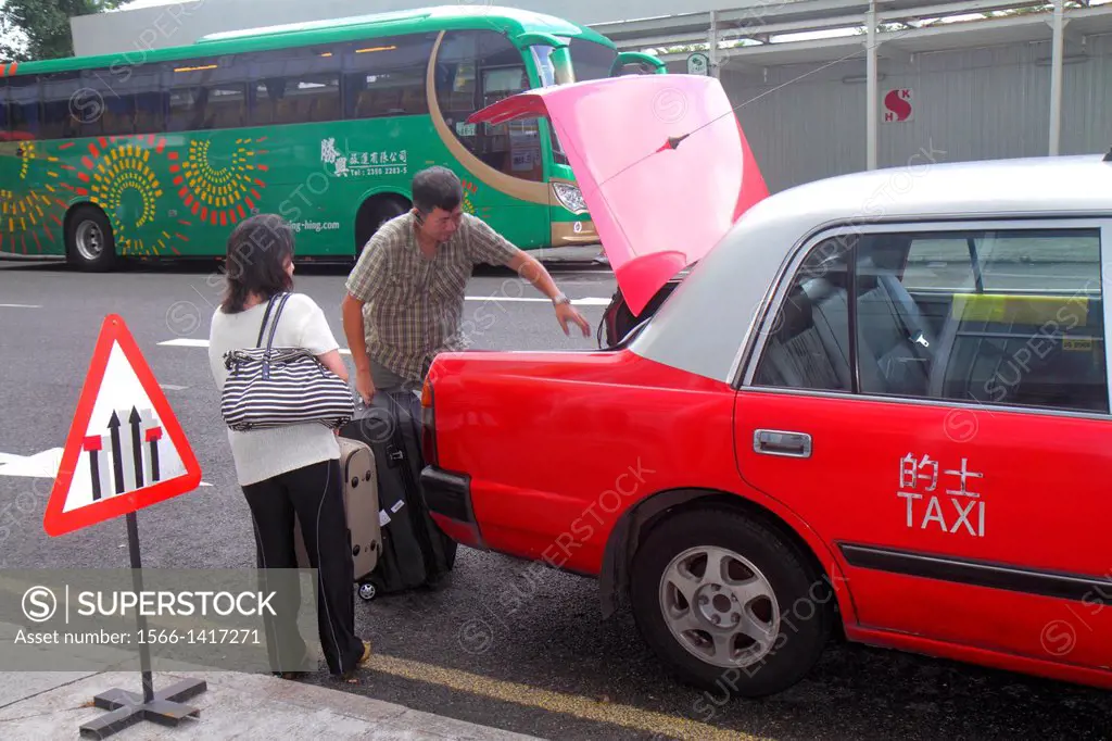 China, Hong Kong, Island, North Point, Java Road, Asian, man, taxi cab, driver, woman, luggage, putting in trunk,.