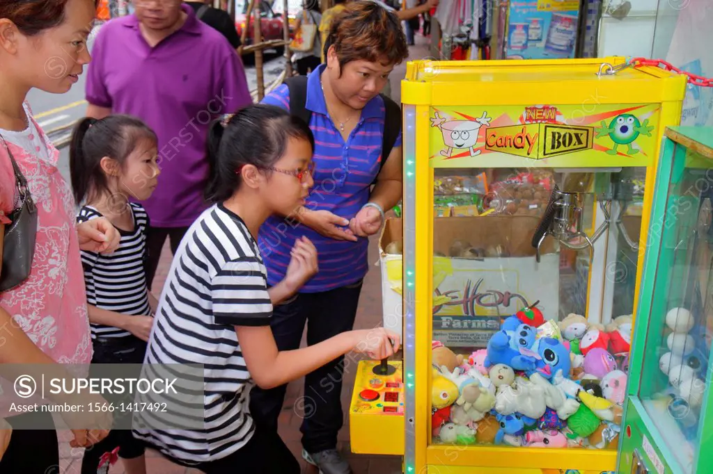 China, Hong Kong, Kowloon, Sham Shui Po, Asian, girl, playing carnival game, claw, prize, stuffed animal, sister, watching,.