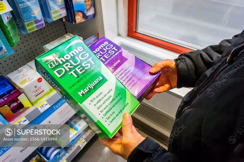 A consumer holds home drug testing kits for marijuana and cocaine in a drugstore in New York
